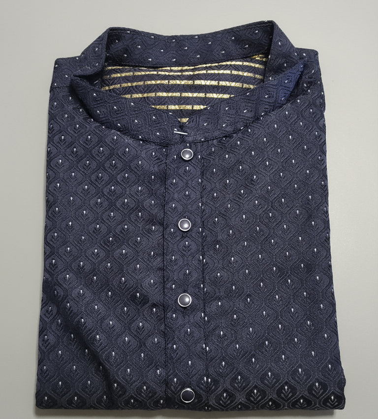 Close-up of a navy blue textured shirt with buttons on a green fabric background