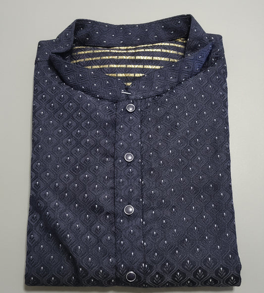 Close-up of a navy blue textured shirt with buttons on a green fabric background
